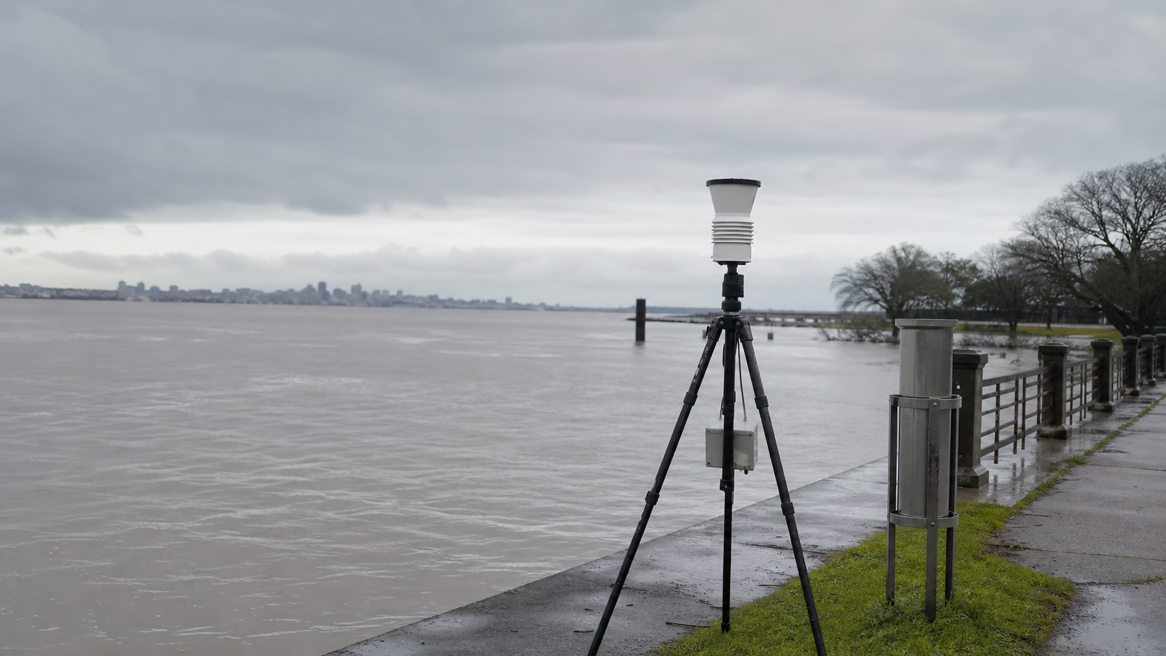 Equipamento genérico de monitoramento diante do Guaíba com nível elevado e céu nublado